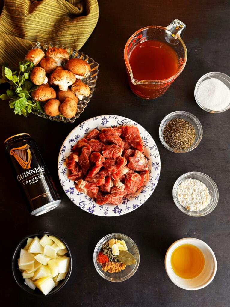 photo of bowls of stew meat, mushrooms, chopped onion, and spices for beef Guinness stew