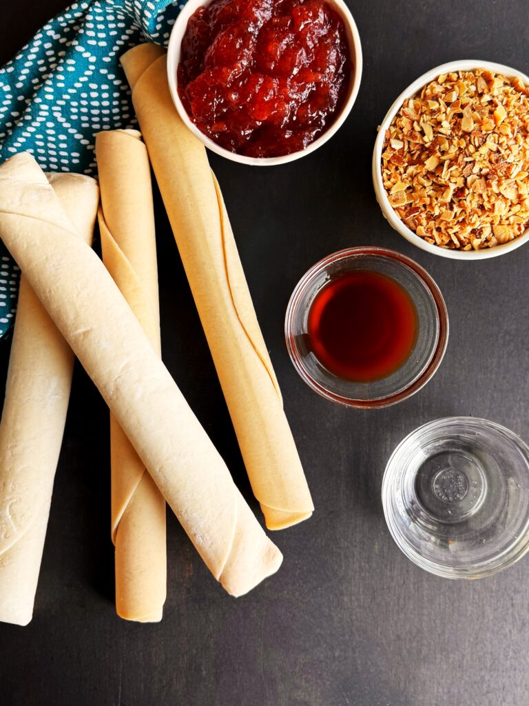 photo of pie dough, strawberry jam, toasted almonds, vanilla, and almond extract for a recipe for homemade strawberry almond pop tarts