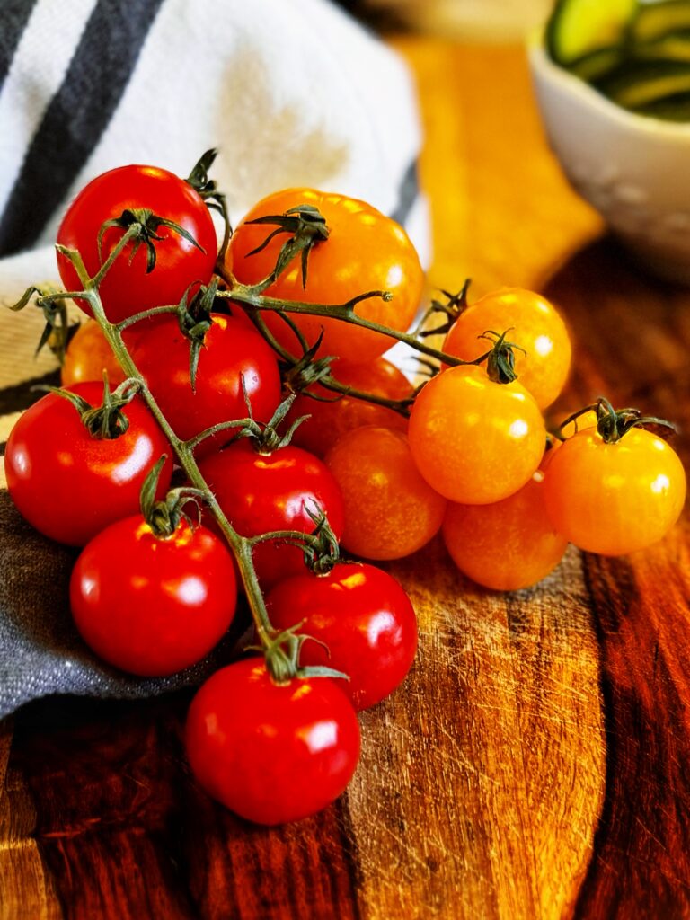 photo of red and yellow cherry tomatoes on the vine