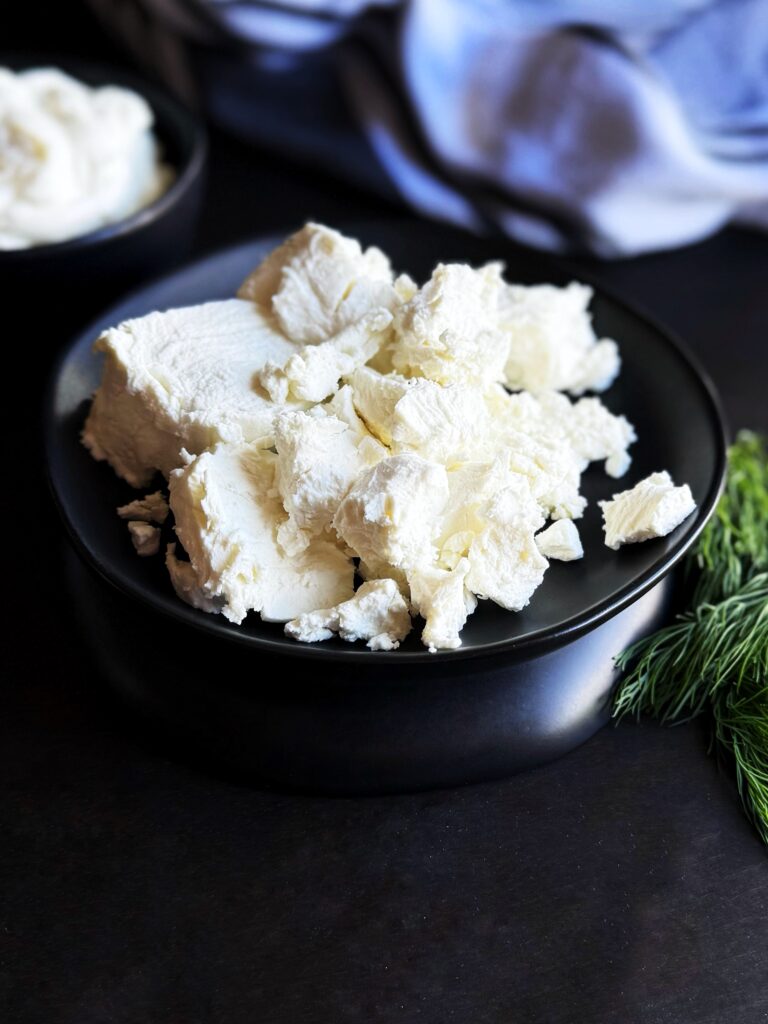 photo of a black ceramic bowl filled with crumbled goat cheese