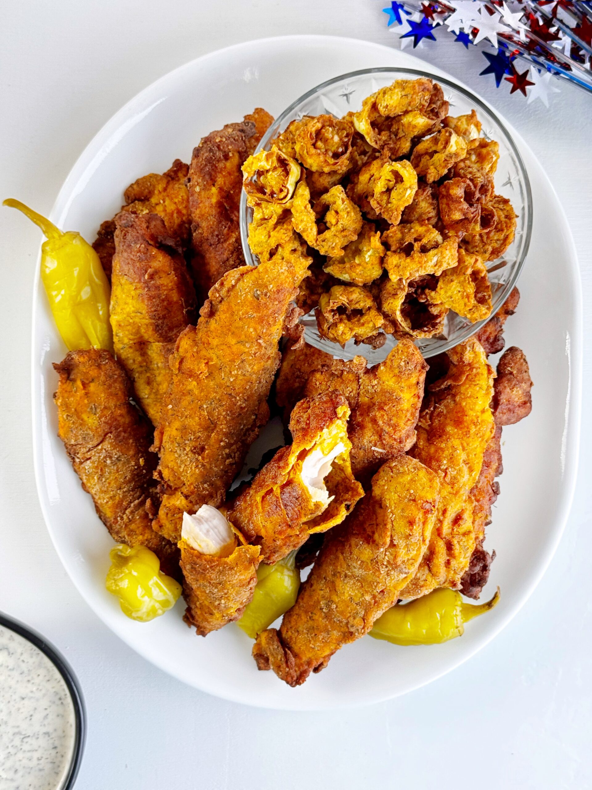 photo of a platter of fried chicken sitting on a white table top